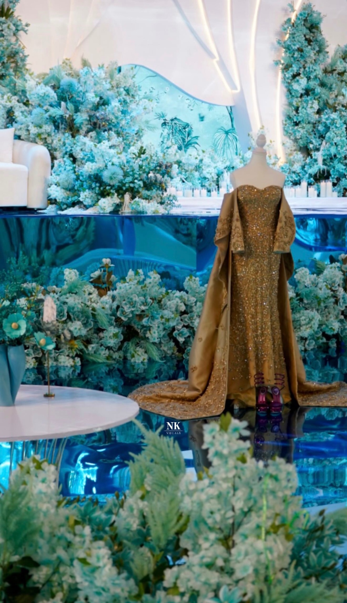 Blue-and-white wedding installation with a gold gown on a mannequin